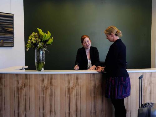 two women are standing at a reception desk at The Sebel Launceston in Launceston
