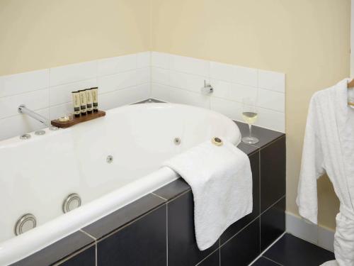 a bathroom with a bath tub with a towel at The Sebel Launceston in Launceston
