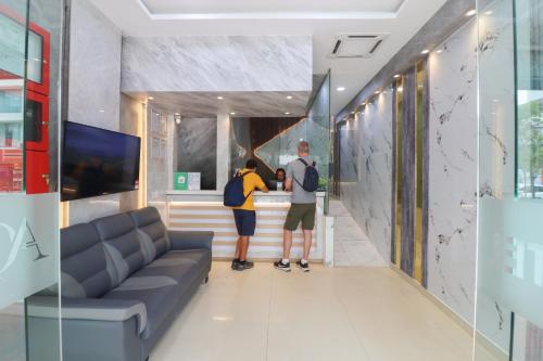 two people standing at a counter in a room at AQ Bukit Bintang in Kuala Lumpur