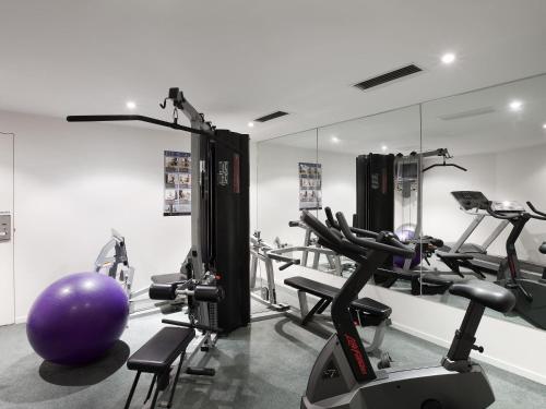 a gym with several tread machines and a purple ball at The Sebel Launceston in Launceston
