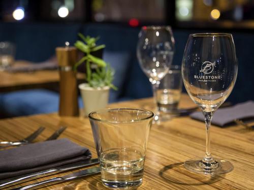 two wine glasses sitting on a wooden table at The Sebel Launceston in Launceston