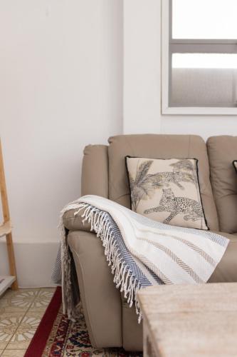 a couch with a blanket on it in a living room at Zen Escape Guest House " Location 1" - Three listings - Romantic Escape, Cozy Delight, Oasis Suite in Brisbane