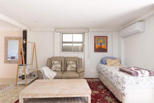 a living room with a bed and a couch at Zen Escape Guest House " Location 1" - Three listings - Romantic Escape, Cozy Delight, Oasis Suite in Brisbane