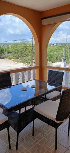 a table and chairs on a balcony with a view at Brytan Villa in Treasure Beach