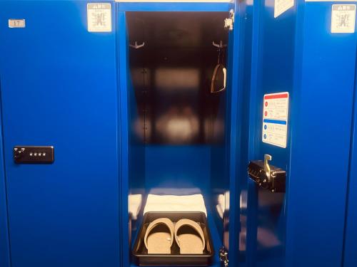 a pair of shoes in a blue locker room at Capsule Hostel Beppu Tower in Beppu