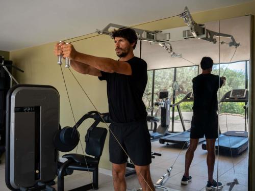 a man standing in a gym with his arms out at Mercure Brignoles Golf de Barbaroux & Spa in Brignoles