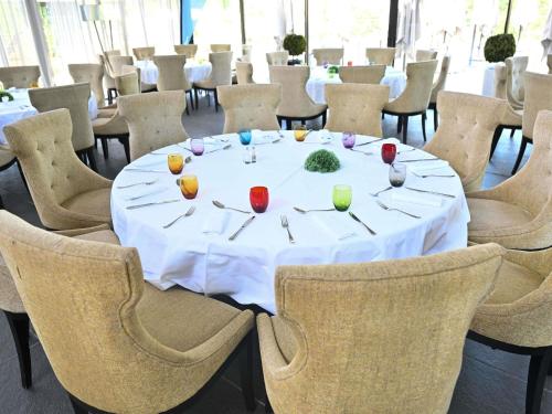 a white table with candles on it in a room with chairs at Mercure Brignoles Golf de Barbaroux & Spa in Brignoles