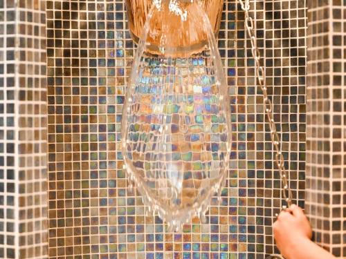 a glass vase hanging on a tiled wall at Mercure Brignoles Golf de Barbaroux & Spa in Brignoles