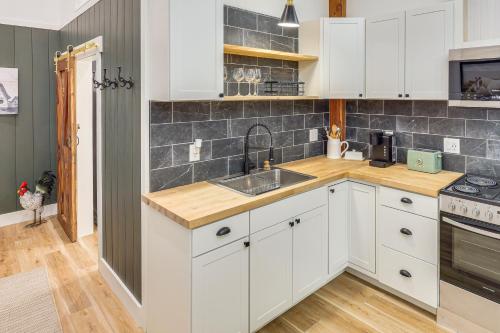 a kitchen with white cabinets and a sink at Luxe Stable Suite Farm Stay in Lebanon! in Lebanon