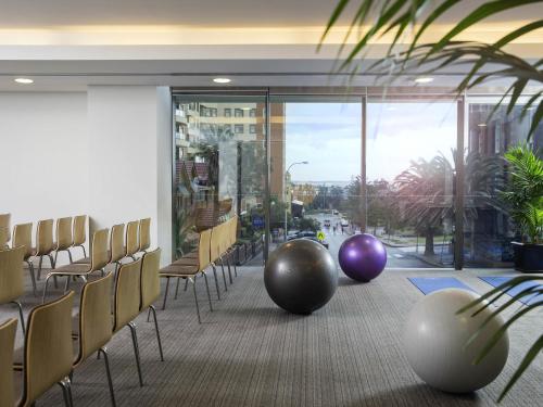 a conference room with chairs and a large window at Novotel Newcastle Beach in Newcastle