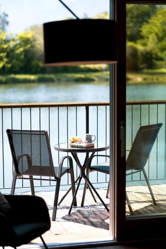 a table and chairs on a balcony with a view of the water at Il Laghetto Hotel in Caiolo