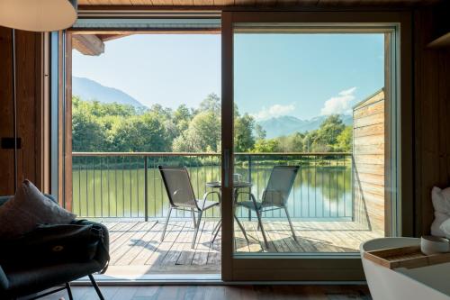 a screened in porch with chairs and a table on a deck at Il Laghetto Hotel in Caiolo