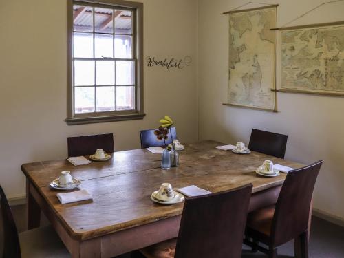 a dining room table with chairs and a large wooden table at Q Station in Sydney