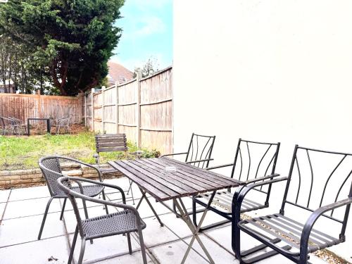 a wooden table and chairs on a patio at Entire New 4 Bed House Southampton 10 Guests in Southampton