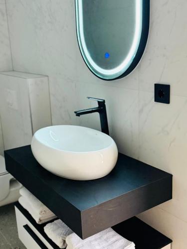 a bathroom with a white sink on a black counter at Turističko naselje Natura Art-Hotel Opal Art in Lohovo
