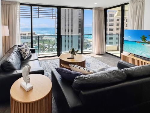 a living room with black furniture and a large window at Oracle 11th floor Tower 1 - GC Getaways in Gold Coast