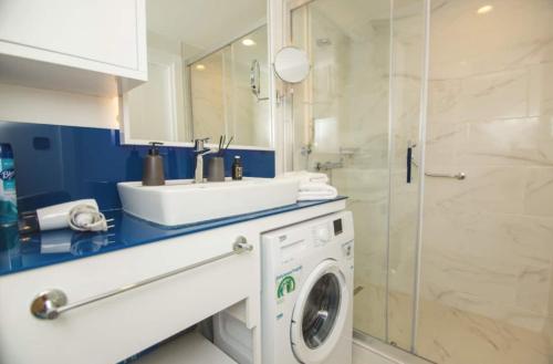 a bathroom with a sink and a washing machine at Astounding Sea View Aparthotel In Orbi City Batumi in Batumi