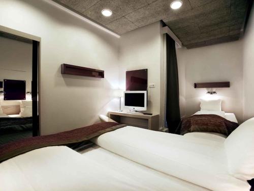 a hotel room with two beds and a mirror at Ibis Styles Stockholm Odenplan in Stockholm