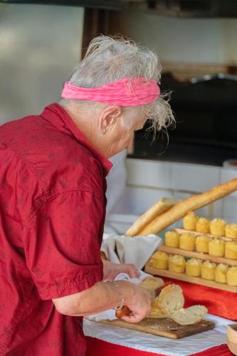 a woman with a pink headband is preparing food at Amed Cafe & Hotel Kebun Wayan in Amed