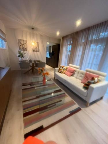 a living room with a white couch and a glass table at Luxe vakantiewoning Hellendoorn Sallandse Heuvelrug nmr 36 in Haarle
