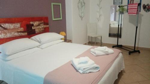 a bedroom with a bed with two towels on it at La Finestra sull'Etna in San Gregorio di Catania