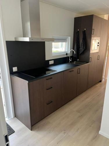 a kitchen with a sink and a counter top at Luxe vakantiewoning Hellendoorn Sallandse Heuvelrug nmr 36 in Haarle