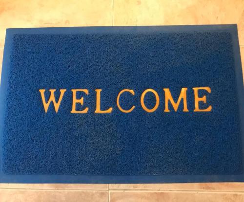a blue welcome mat with the word welcome at Auberge Villa des Jasmins in Aghroude