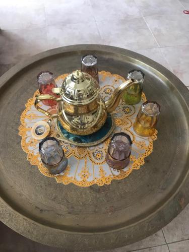 a tea pot and glasses on a table at Auberge Villa des Jasmins in Aghroude