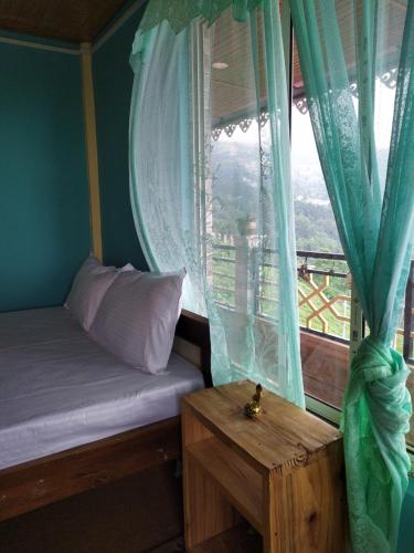 a bedroom with a bed and a window at The Garden View Family Homestay in Takdāh