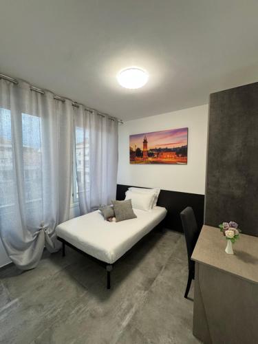 a bedroom with a white bed and a table and window at Moro Luxury Rooms in Grassobbio