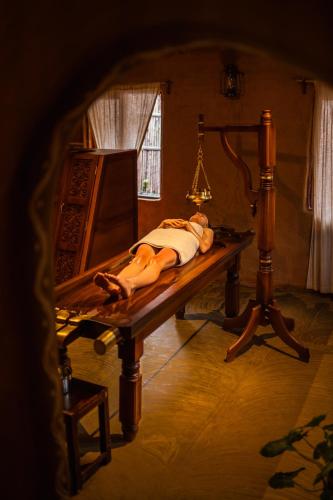 a person laying on a table in a room at The Mudhouse Marayoor in Munnar