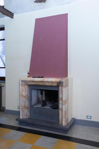 a fireplace in a room with a purple wall at Residenza d'epoca Palazzo Franciosoni in Vetralla