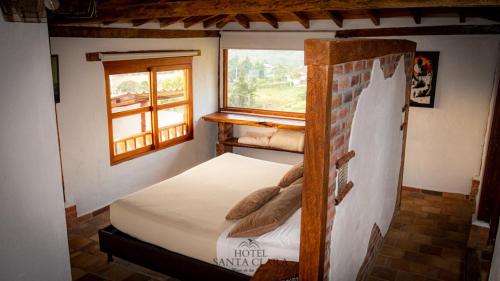 a small bedroom with a bed and a window at Hotel Boutique Santa Clara Mesa de los Santos in Los Santos