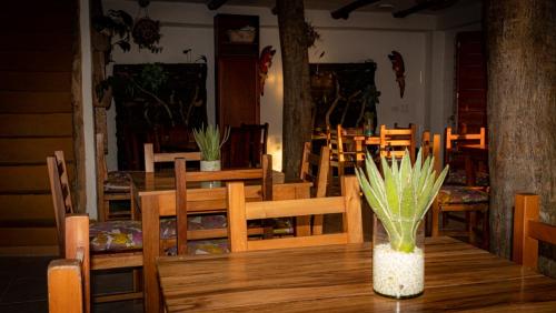 a dining room with wooden tables and chairs and a vase at Hotel Boutique Santa Clara Mesa de los Santos in Los Santos