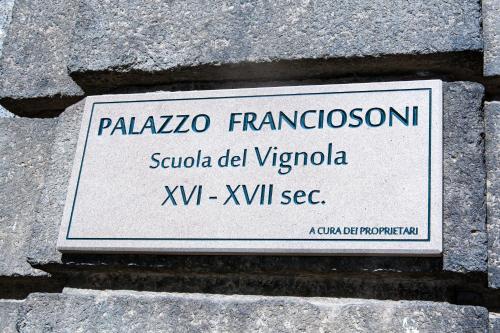 a sign on the side of a stone wall at Residenza d'epoca Palazzo Franciosoni in Vetralla