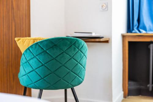 a green chair sitting in front of a fireplace at Hotel Bristol Metz Centre Gare in Metz