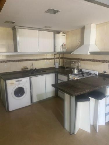 a kitchen with a sink and a washing machine at Duplex 1 Villa Ramallo in Estación Ramallo