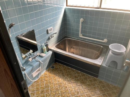 a bathroom with a tub and a sink at Iioka-classic in Asahi