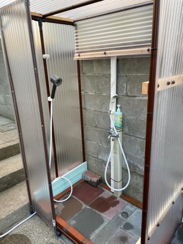 a shower in a building with a hose at Iioka-classic in Asahi