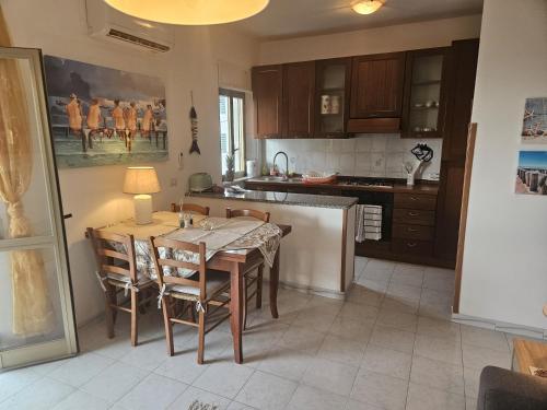 a kitchen with a table and chairs in a kitchen at Villa Butterfly in Santa Domenica