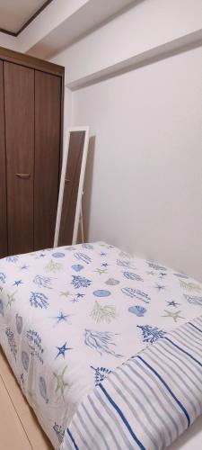 a bedroom with a bed with a blue and white comforter at Sea Bloom Hotel in Dejimamachi