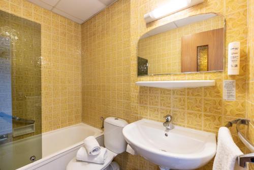 a bathroom with a sink and a toilet and a mirror at Hotel Bristol Metz Centre Gare in Metz