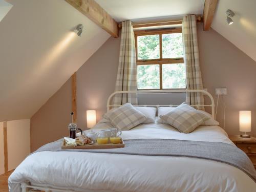 a bedroom with a large bed with a window at Woodpecker Rest in Cilgerran