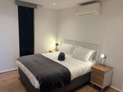 Un dormitorio con una cama con un gato sentado en ella. en Farmstyle Chic Designer Apartment, en Ciudad del Cabo
