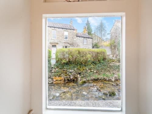 een schilderij van een beek voor een huis bij Victoria Cottage in Kettlewell