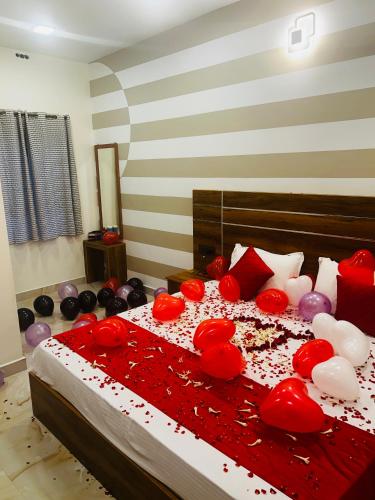 a bedroom with a bed covered in red and white balloons at Aps inn munnar in Munnar