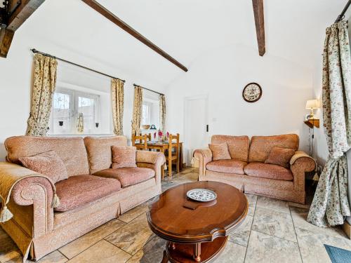 ein Wohnzimmer mit zwei Sofas und einem Tisch in der Unterkunft The Cottage in South Barrow