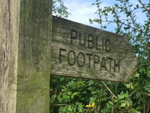 a sign that reads public footpath attached to a pole at Poplar Bungalow in Lyng