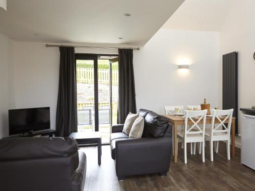 a living room with a couch and a dining room table at Ash Barn - Fernhill Farm in Ryde