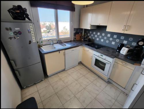 a kitchen with a refrigerator and a sink at T2 top floor with balcony - Stadium-Arena-Eurexpo in Décines-Charpieu